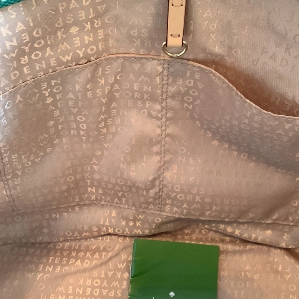 Kate Spade cream colored cloth tote with green leaf pattern.
